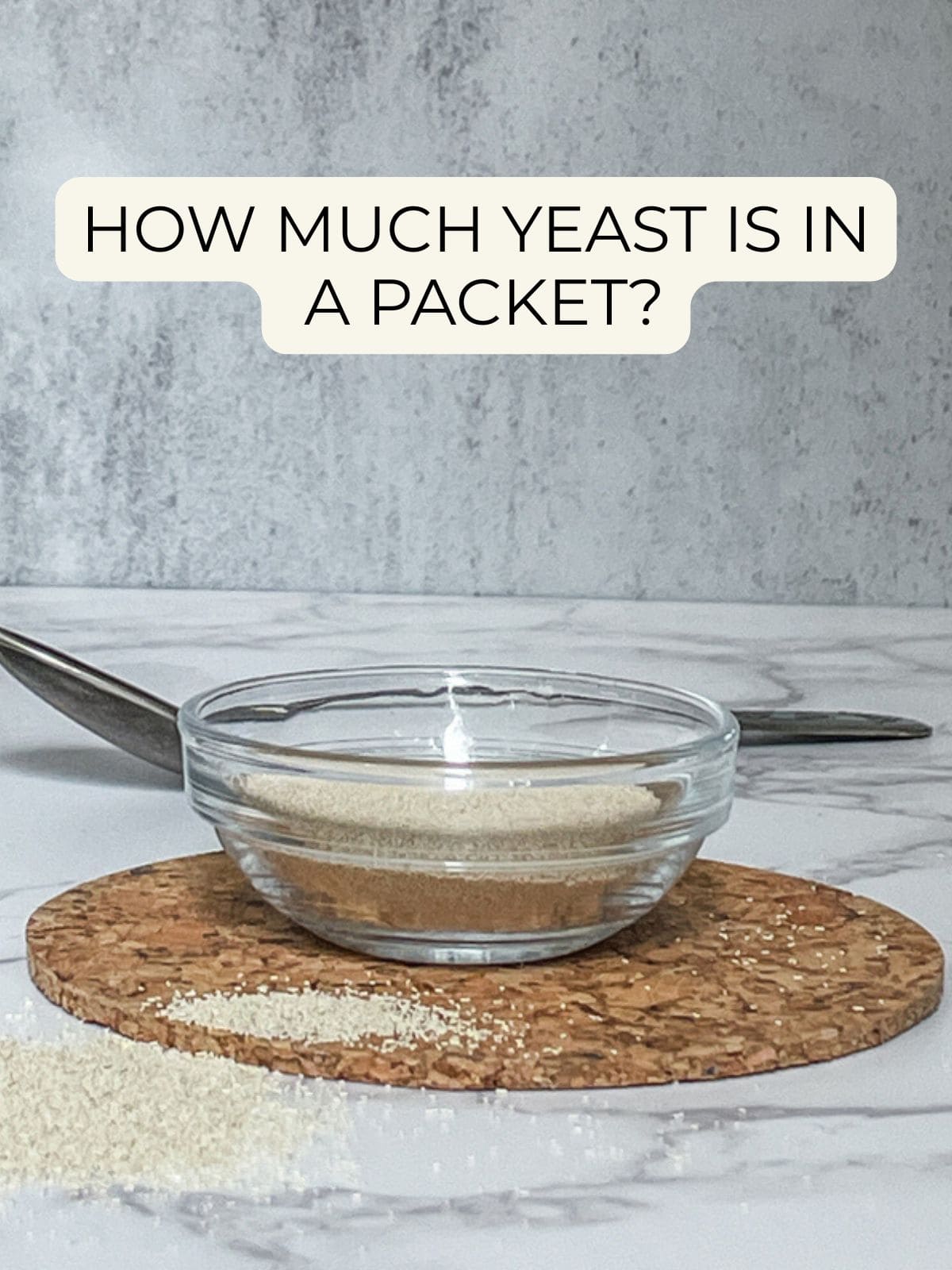 Instant yeast in a bowl with text overlay: How much yeast is in a packet.