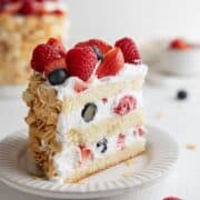 A single slice of mixed berry cake on a white dessert plate.