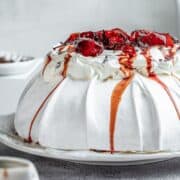 Plum Pavlova with poached plums and chocolate shavings on top.
