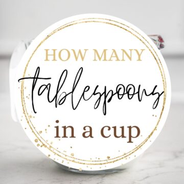 A cup of milk with text overlay: How many tablespoons in a cup.