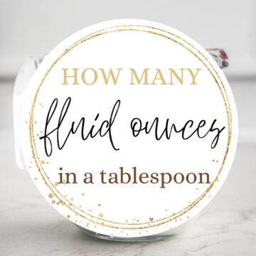 A cup of milk with text overlay: How many fluid ounces in a tablespoon.