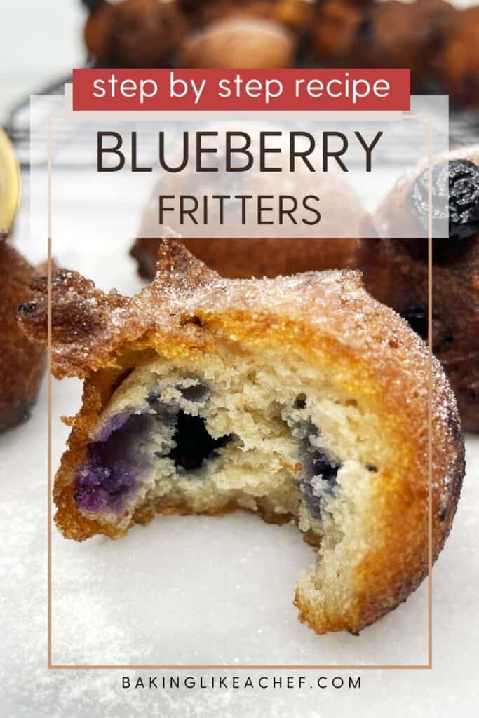 Bitten blueberry fritter with other fritters on a wire rack in the background: Pin with text.