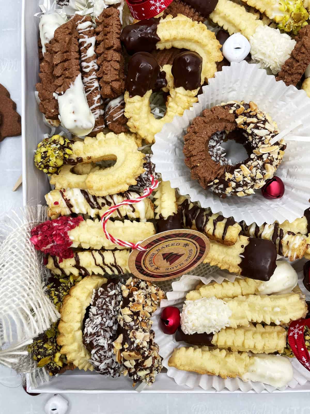 Holiday cookie box loaded with differently decorated cookies and small Christmas decorations: Overhead view