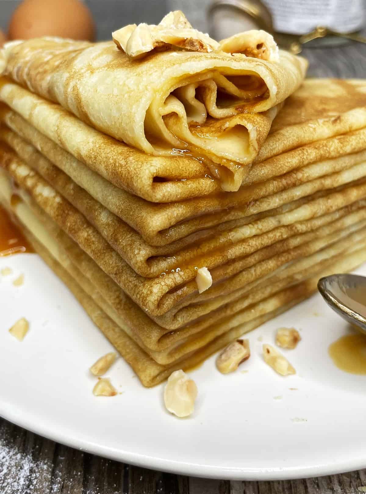 A crepe stack with poured caramel from the top crepe