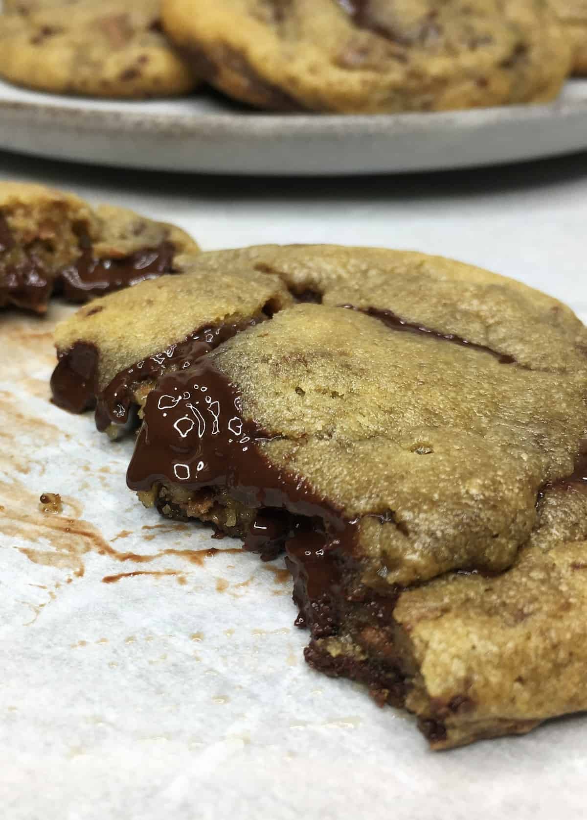 A piece of the chocolate cookie with the rest of the cookies on a plate