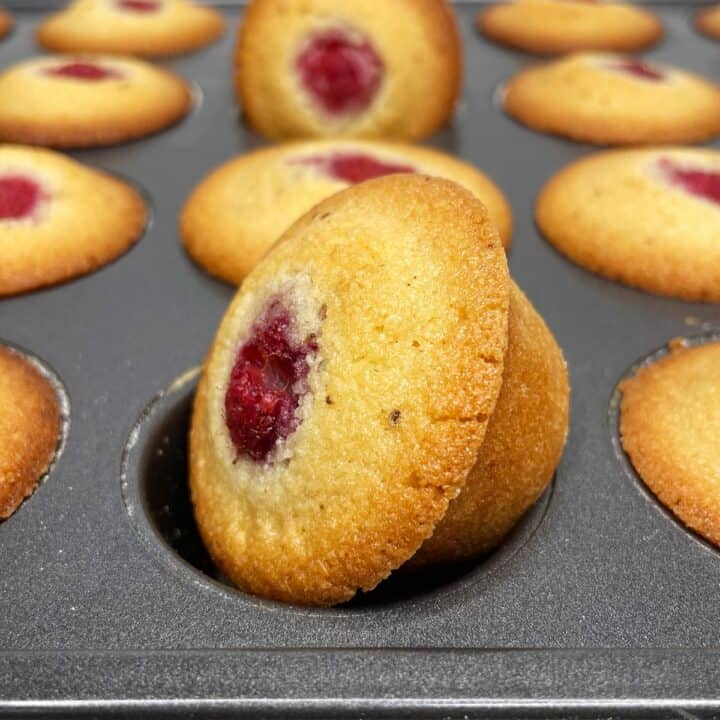 A batch of baked raspberry financiers in a mini muffin mold