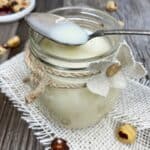 Homemade condensed milk with a spoon in a jar.