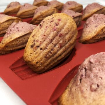 A batch of raspberry madeleines in a red mold