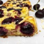 Sliced cherry tart featuring cherries on parchment paper