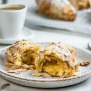 Halved French almond croissant on a dessert plate.