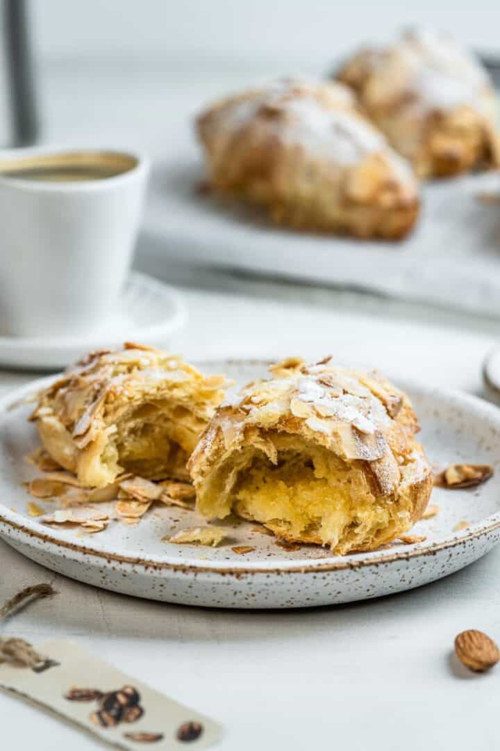 Halved French almond croissant on a dessert plate.