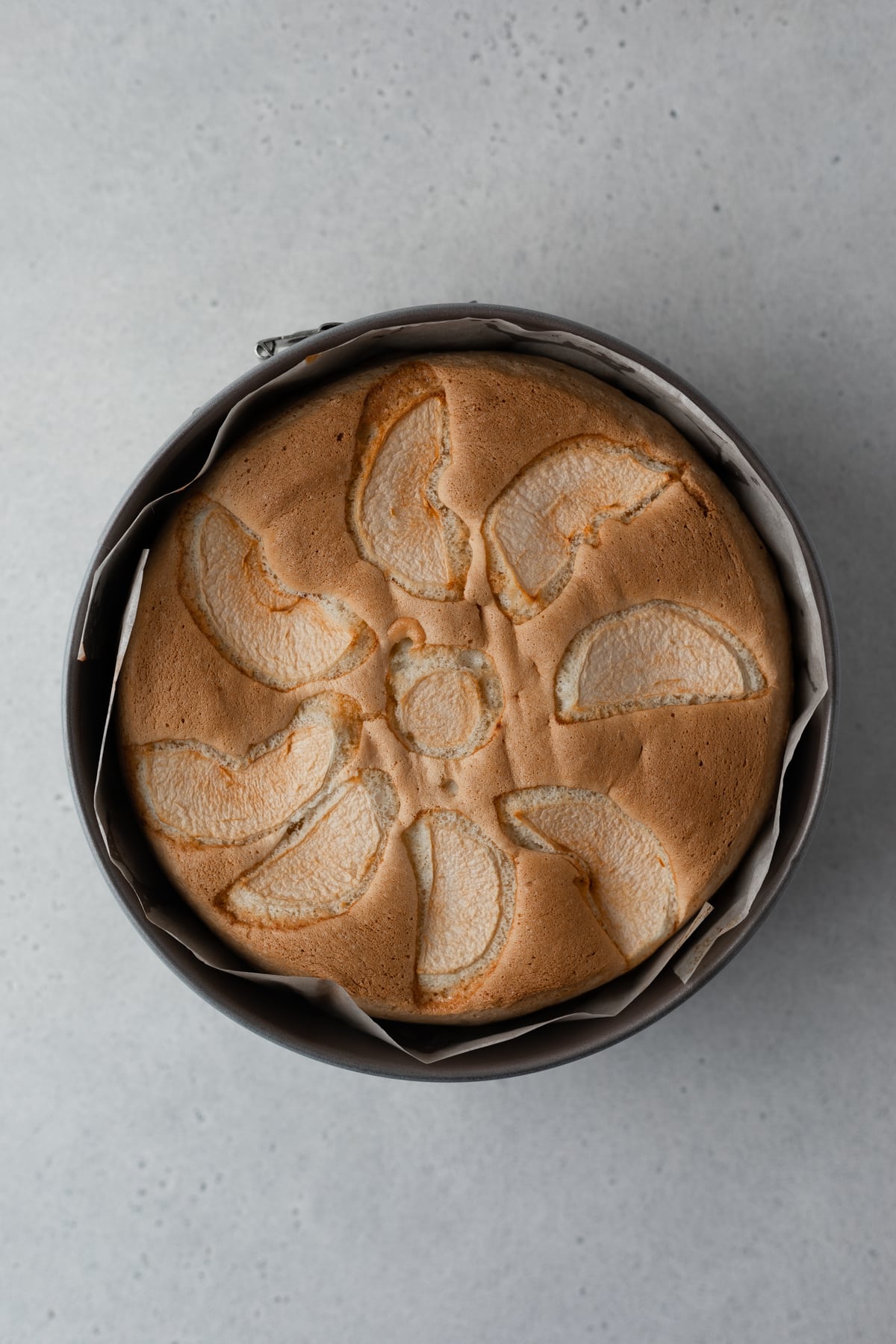 Baked apple sponge cake in a baking mold.