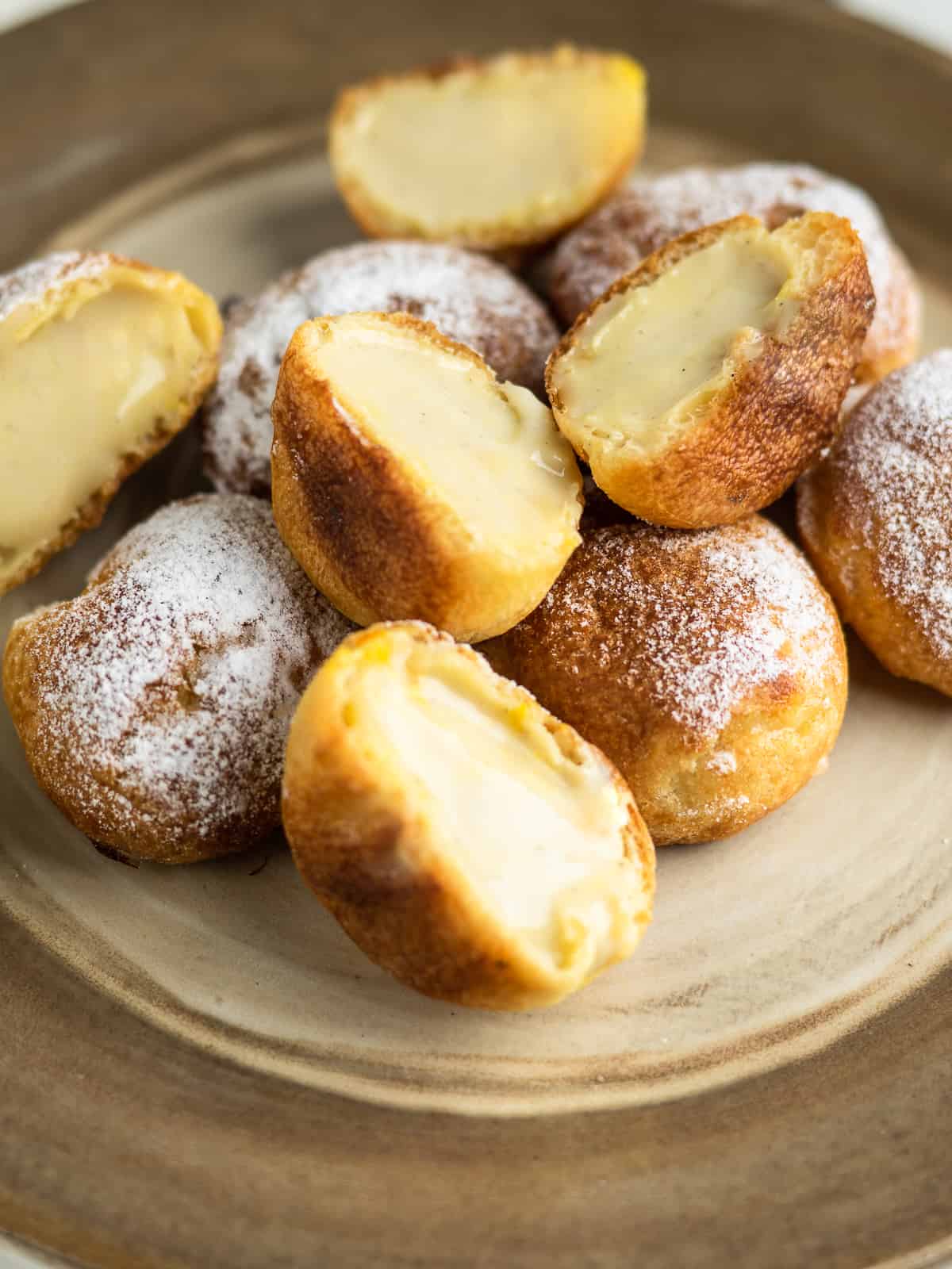 Custard cream puffs filled with vanilla pastry cream on a plate 