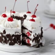 Sliced Black Forest cake on a white cake stand.