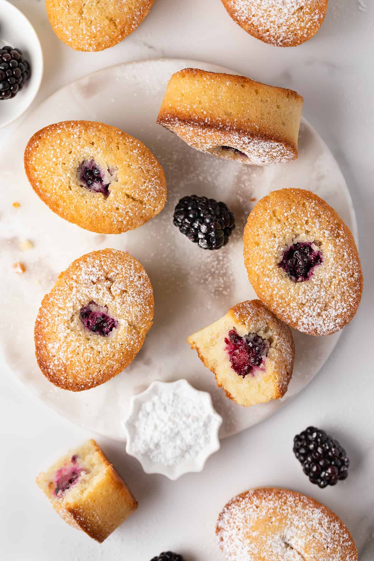 A batch of blackberry almond cakes on a marble board 