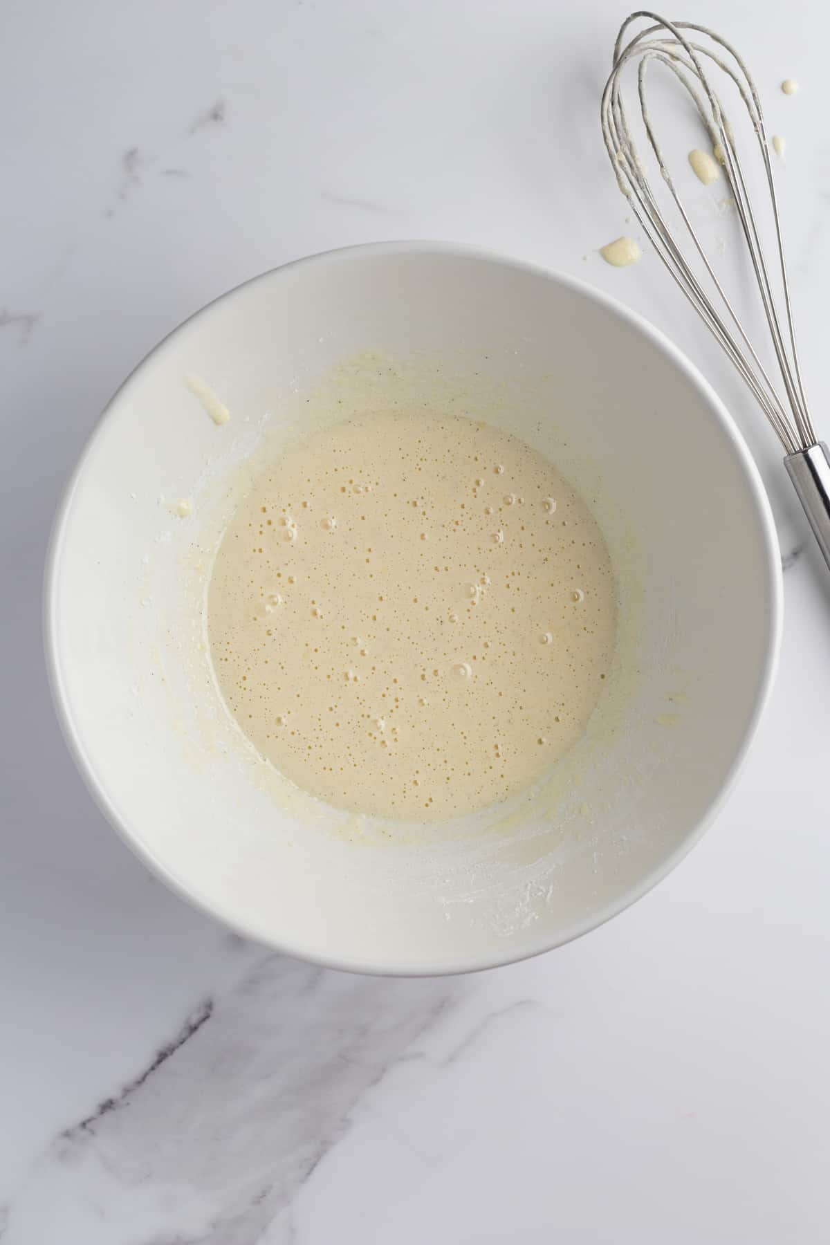 Egg yolk mixture in a bowl with a whisk 