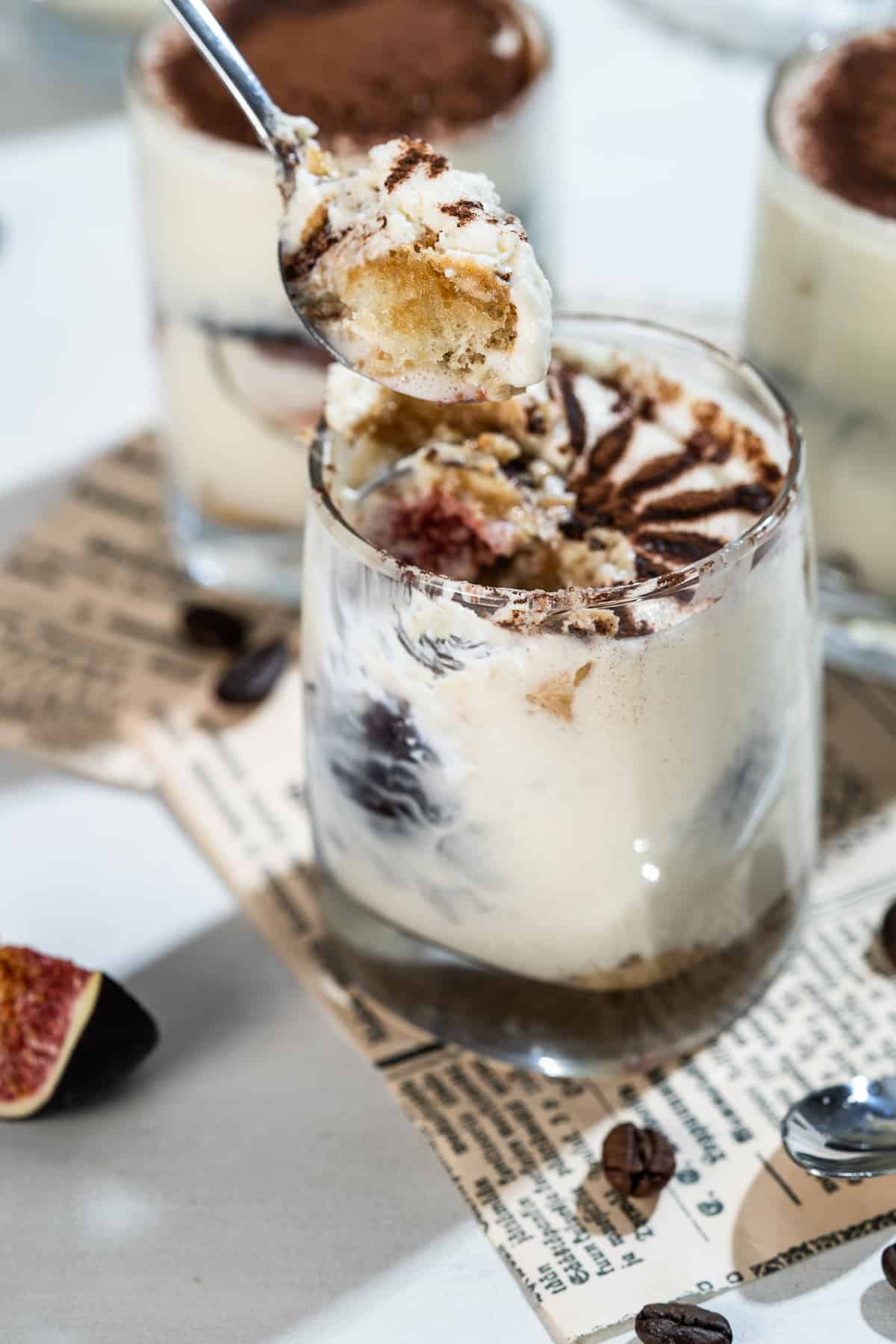 Fig tiramisu in a cup with a spoon.