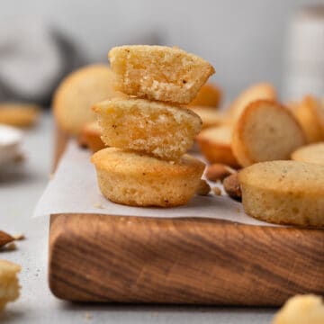 French financiers with almonds on a wooden board lined with parchment.