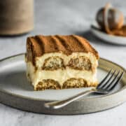 Slice of original tiramisu on a dessert plate with a fork.
