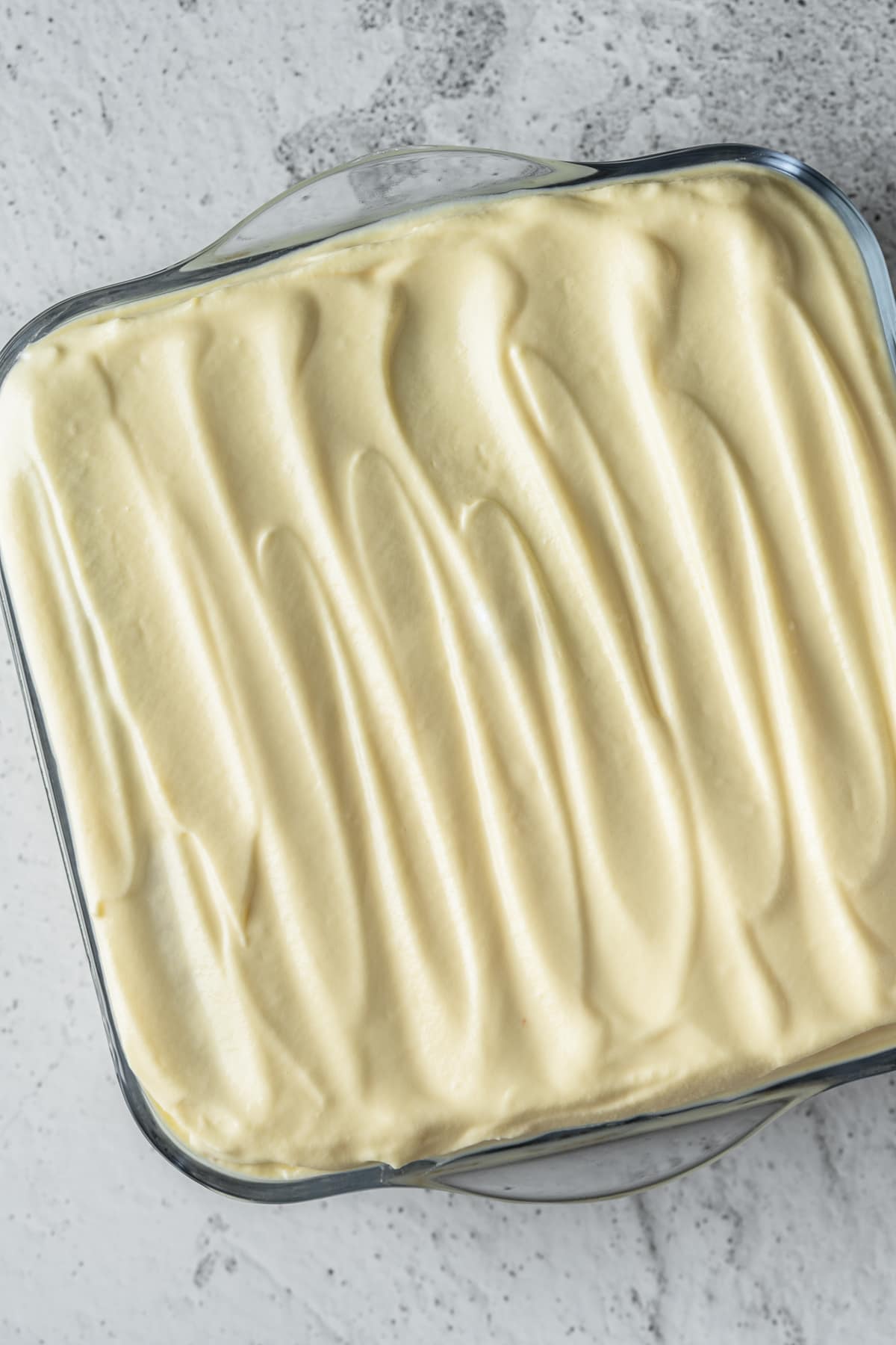 Assembled Italian tiramisu in a glass dish.