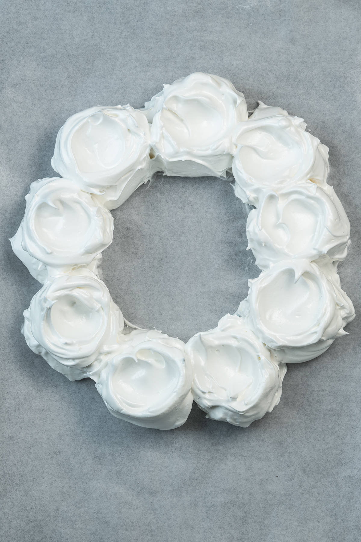 Meringue mounds on parchment paper.
