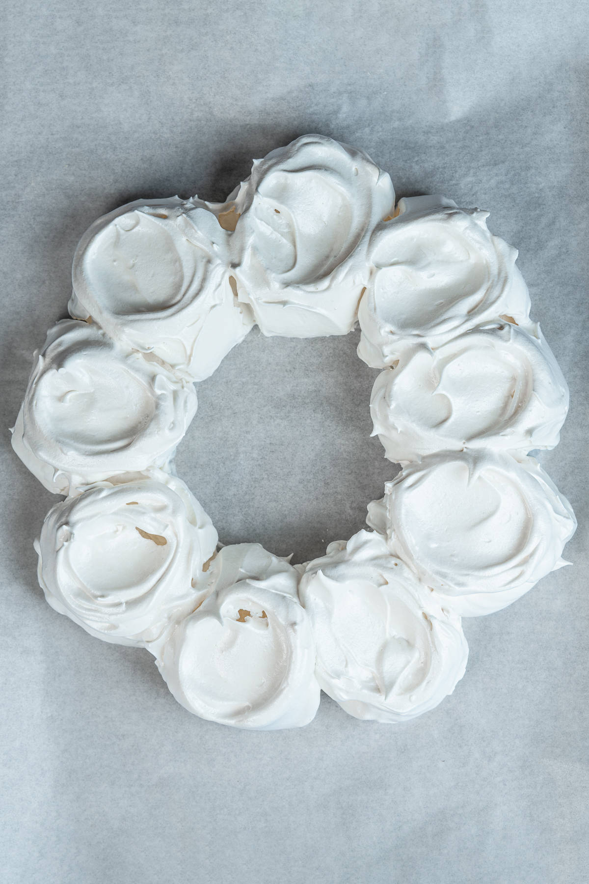 Baked meringue wreath on parchment paper.