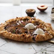 Peach and blueberry galette with a scoop of ice cream on top.