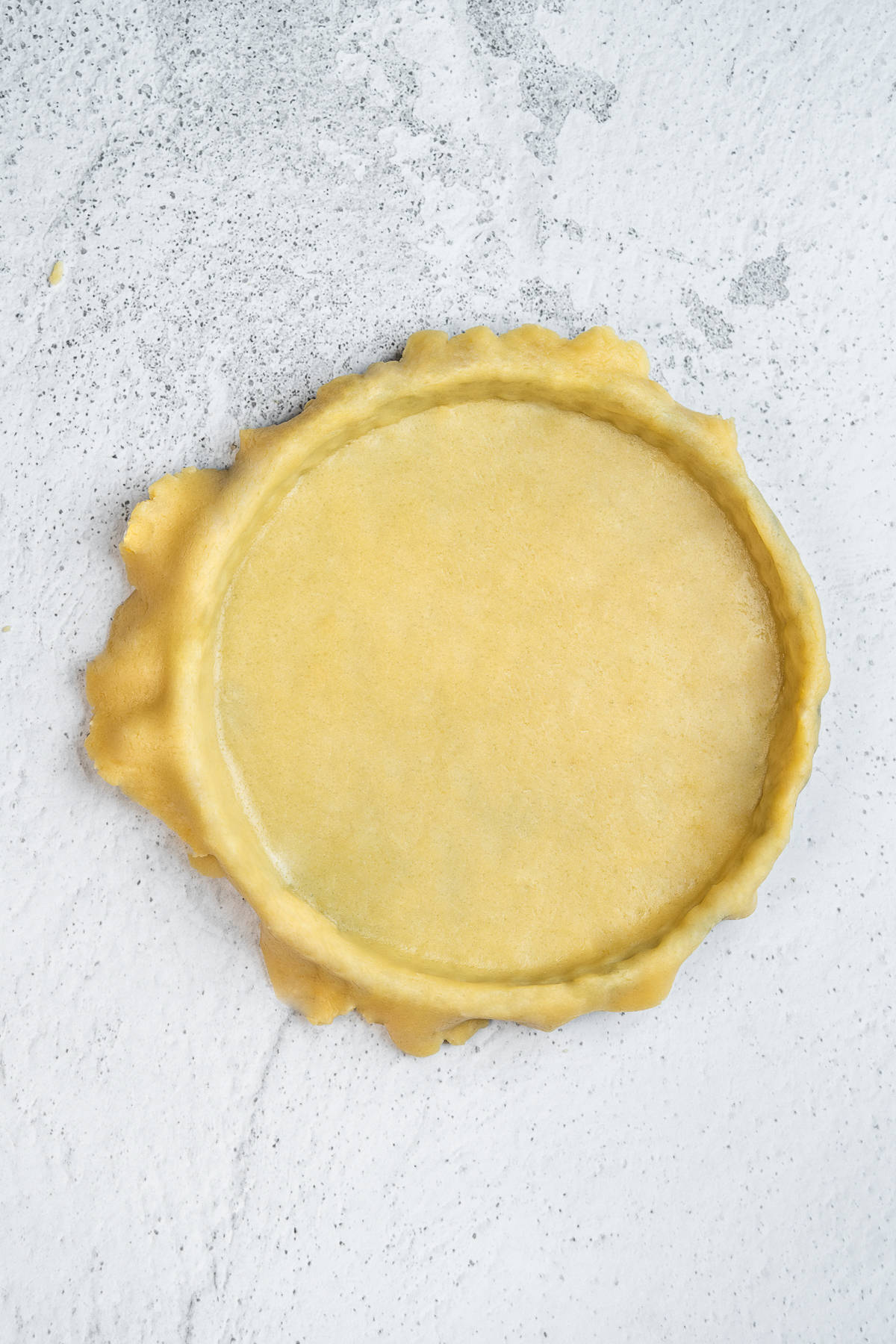 The dough over a tart tin.