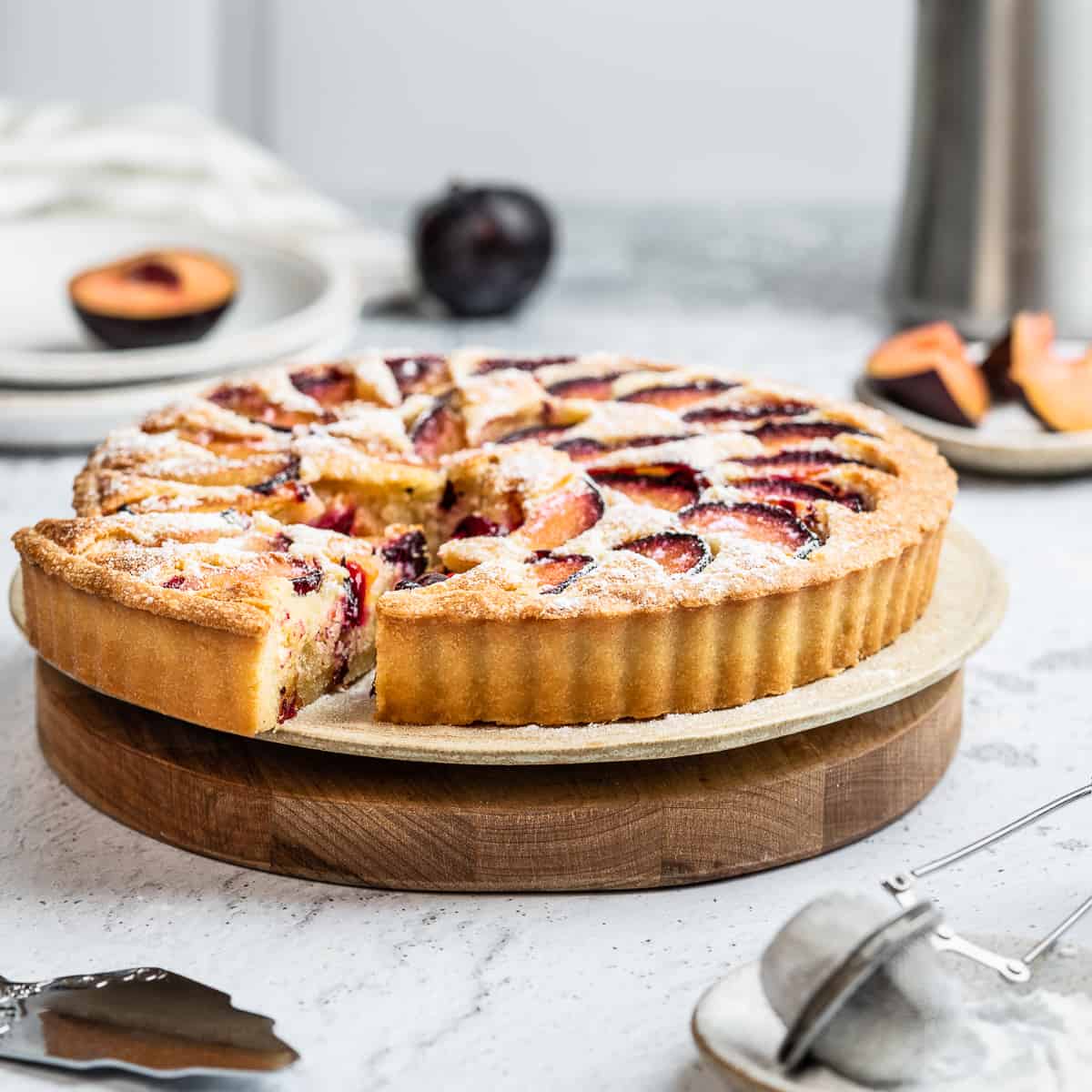 Plum frangipane tart on a serving board.