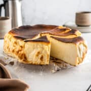 Sliced San Sebastian cheesecake on parchment paper.