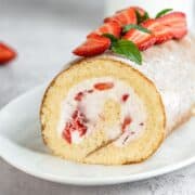 Strawberry swiss roll cake on a serving platter.