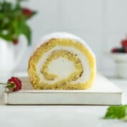 Vanilla sponge cake roll on a serving board.