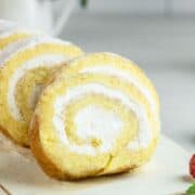 Sliced vanilla sponge cake roll on a serving platter.